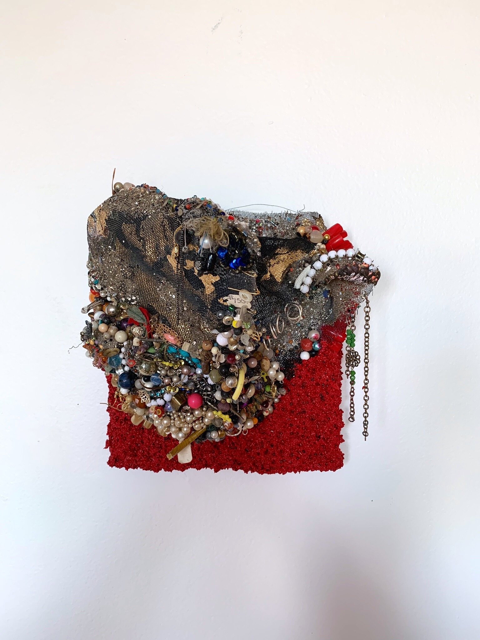   Filed Down,  2019, costume jewelry, found objects, metal screen, fake nails resin, and pumice medium on panel, 8x8” 