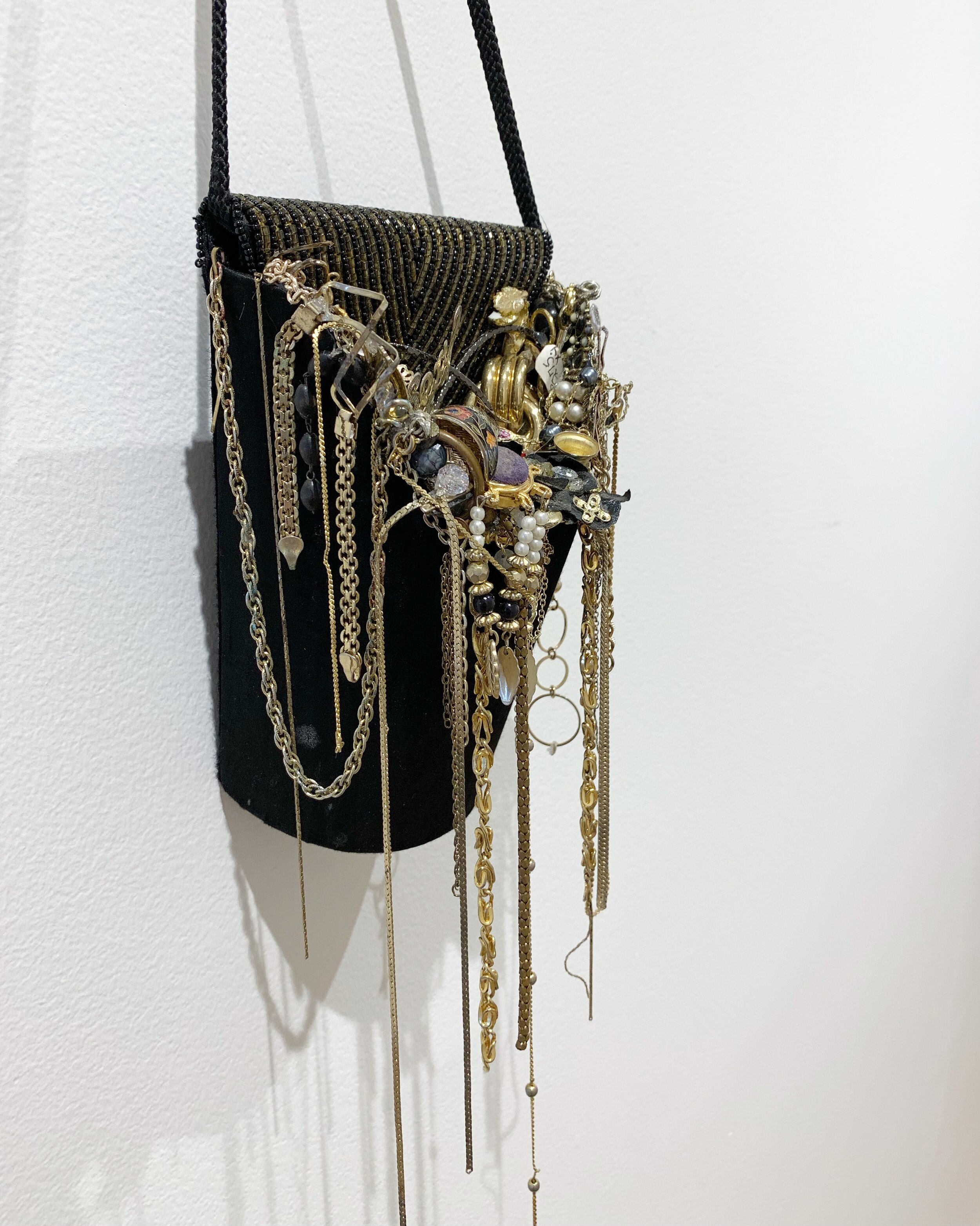   Party Bag,  2019, costume jewelry and gold chains in black purse, 6x24” 