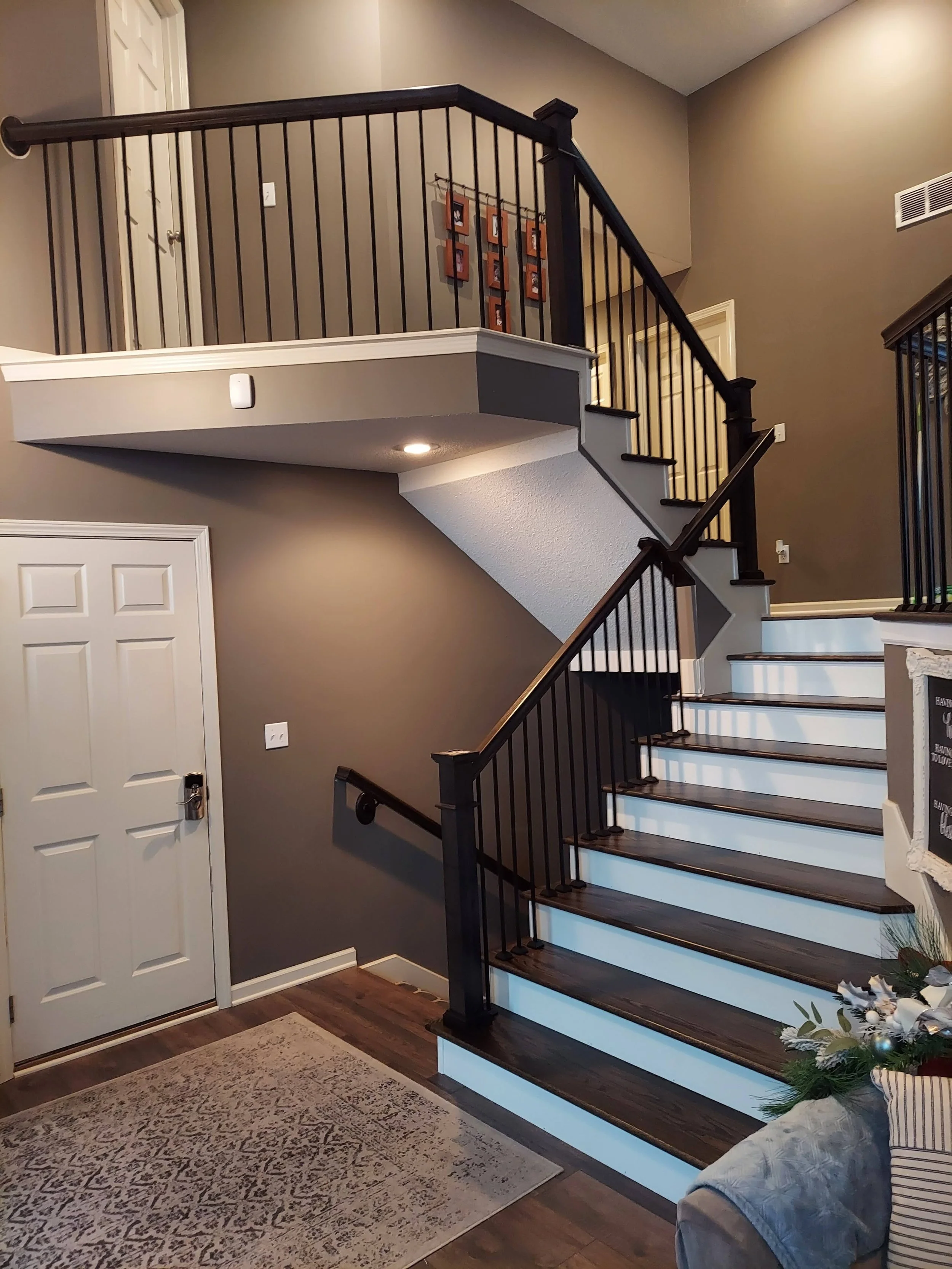 Hardwood staircase with black iron balusters and handrail