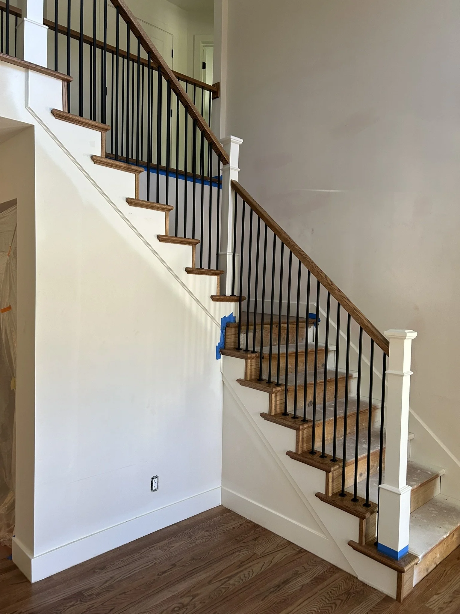 Hardwood staircase with wood handrail and black balusters