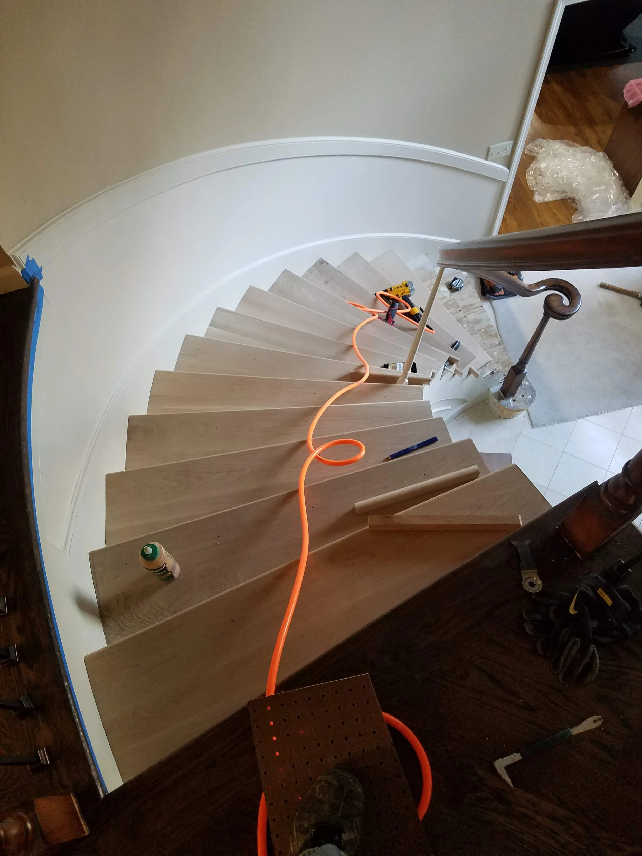 Curved hardwood staircase installation in progress