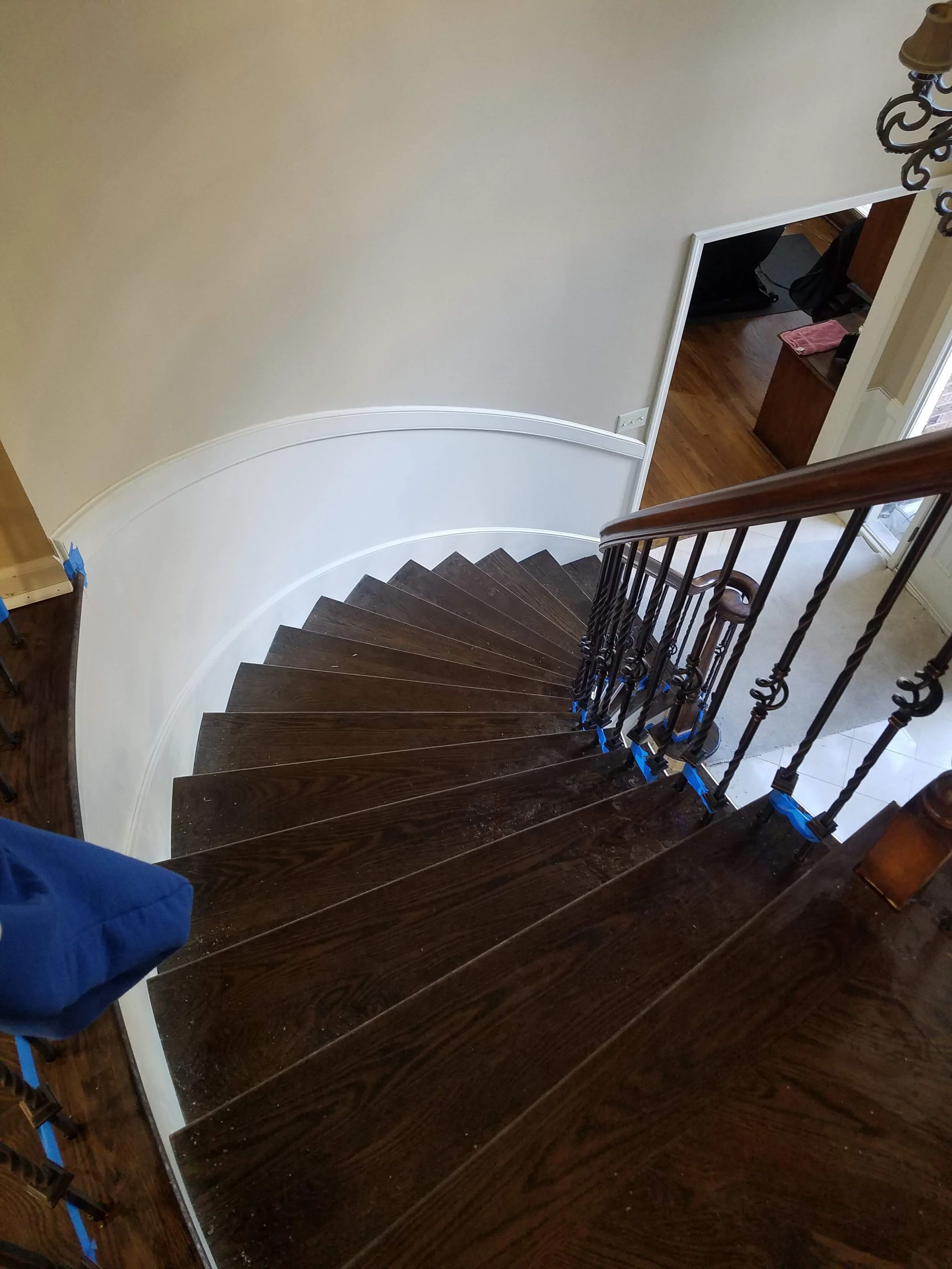 Finished curved hardwood staircase with dark stain