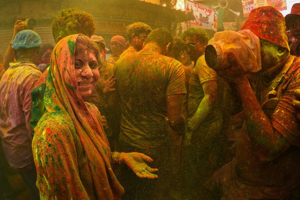 A woman covered in Holi colours