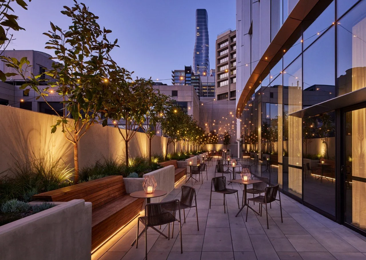 An outdoor function space with fairy lights and tea lights.