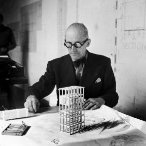 c-nina-leen-time-life-getty-images-subject-charles-edouard-jeanneret-gris-swiss-architect-instrumental-in-developing-the-international-style-architect-le-corbusier-studying-architectural-plans-small-model-of-building-in-his-office-paris-fran.jpg