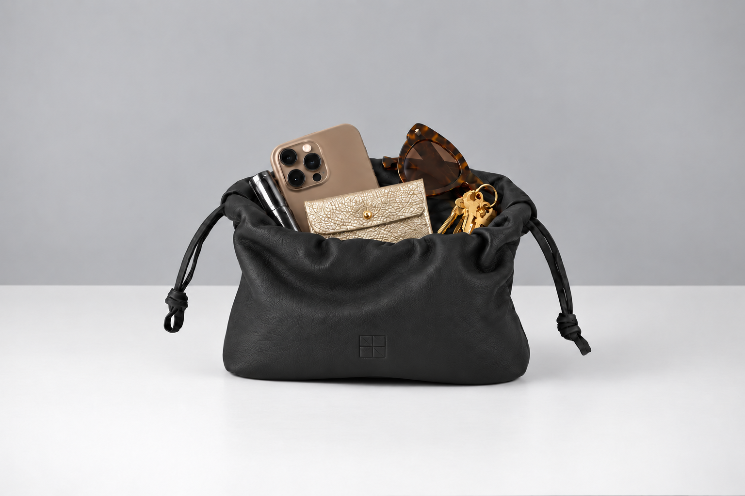 Schwarze Ledertasche auf neutralem Studiohintergrund.png