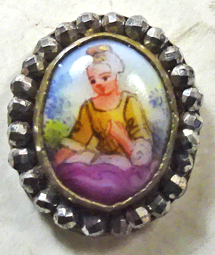 Small porcelain figure in cut steel rim