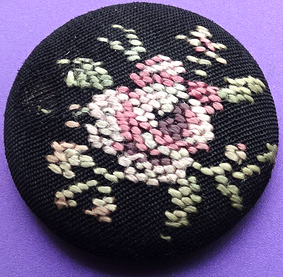 Embroidered rose on black fabric