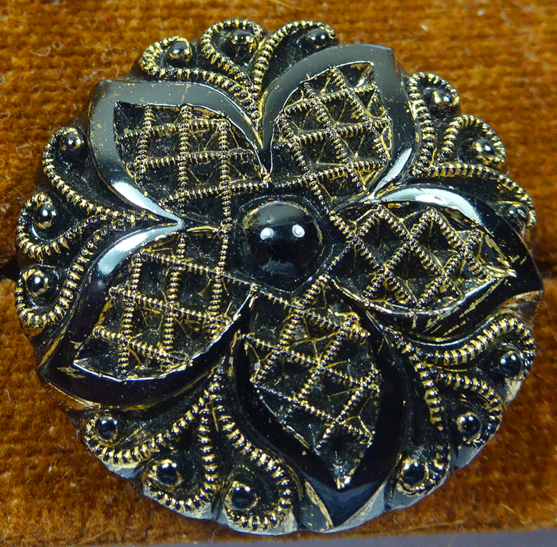 Black glass with molded flower and gold lustre