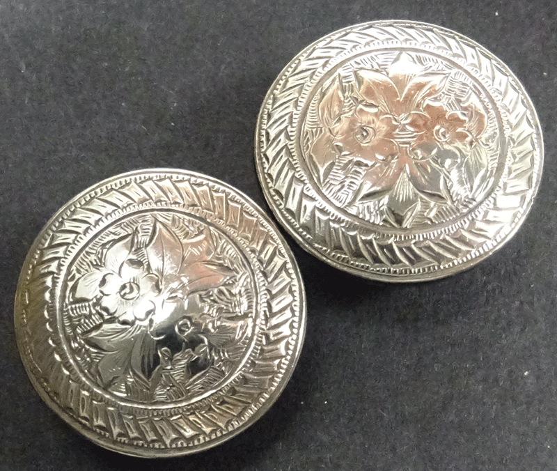 Pair of engraved silver coloured stud buttons