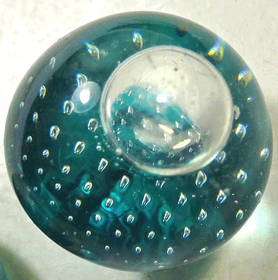 Small clear glass with bubbles on turquoise background