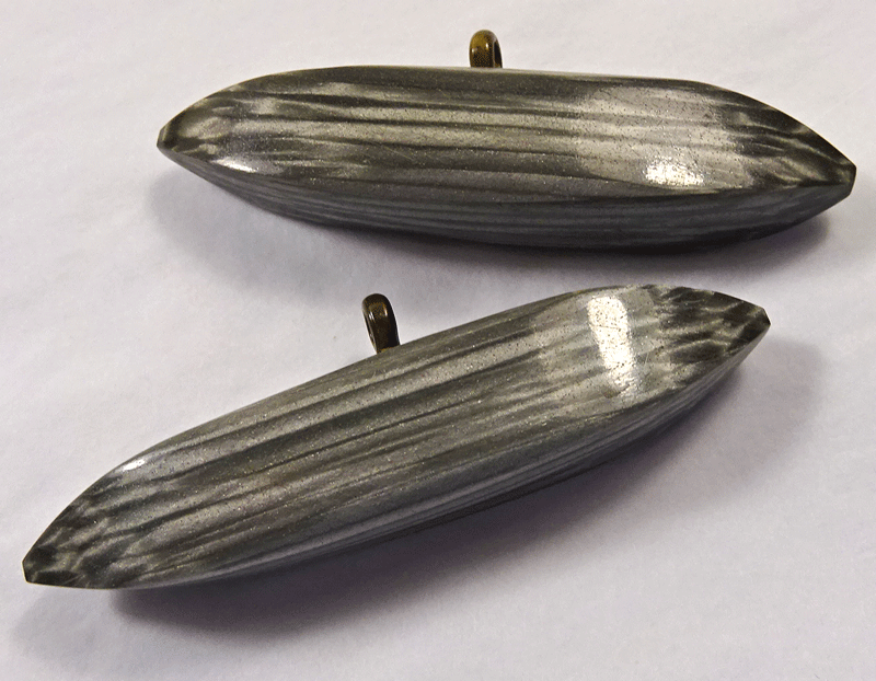 Pair of long grey and white torpedo shape buttons
