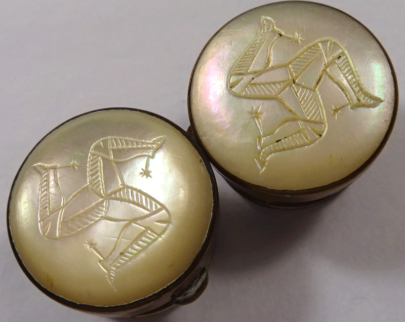 Pair of pearl topped Wests Patent solitaires, carved triskelion symbol
