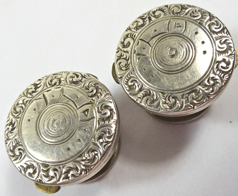 Pair of Wests solitaires, scrolly rims, pearl backs