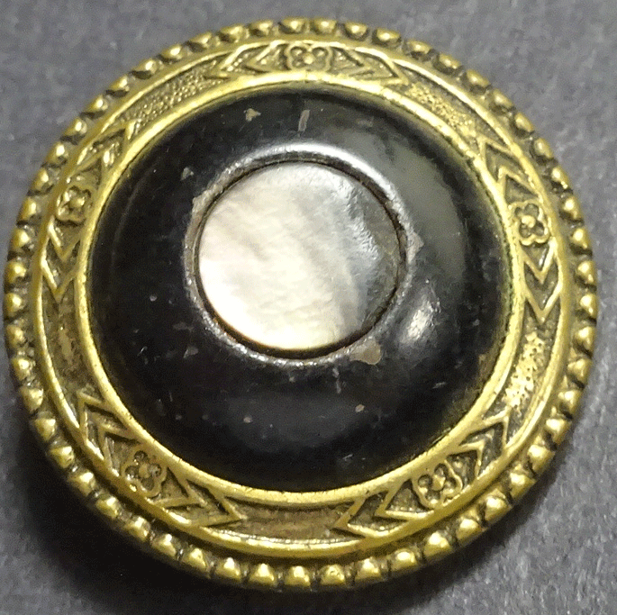 Pearl in black metal dome, gilt rim