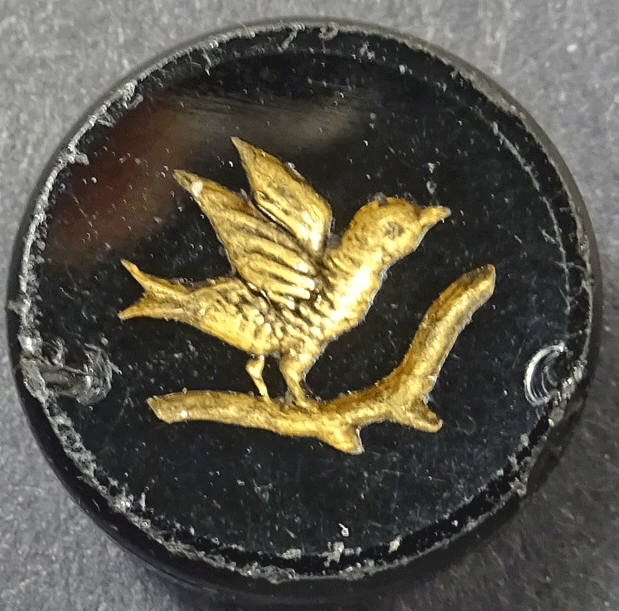 Gold intaglio bird on black glass