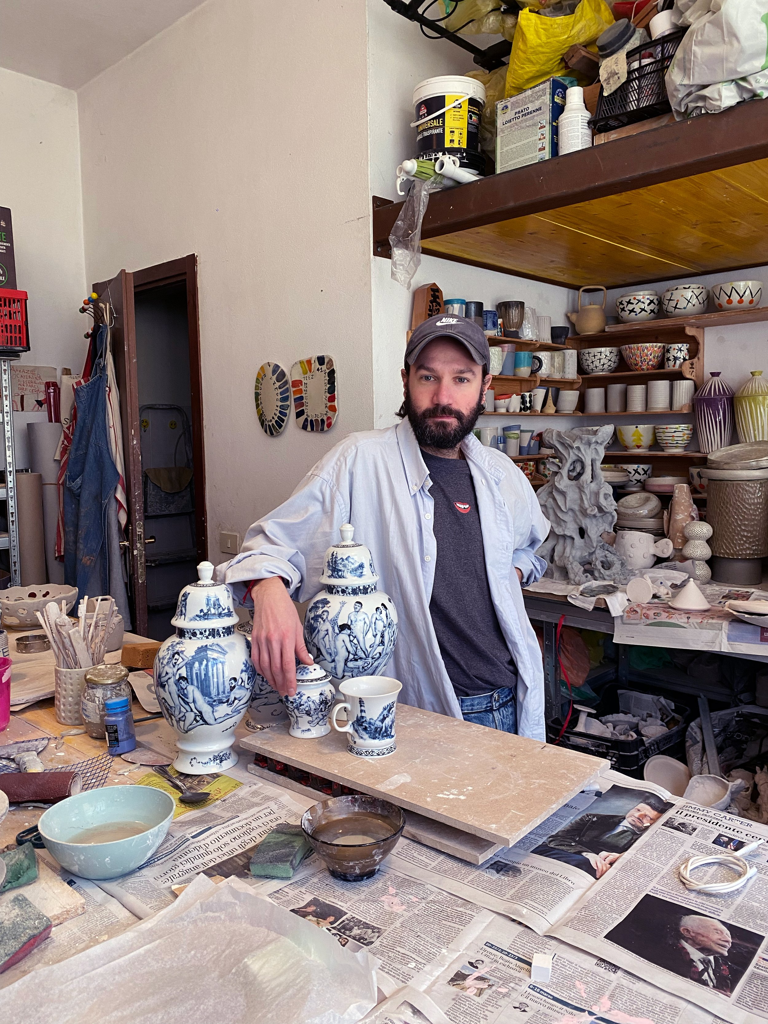 Andrea Semeghini Art Director behind Vanadio23 is posing in the ceramic studio with some of his ceramic creations