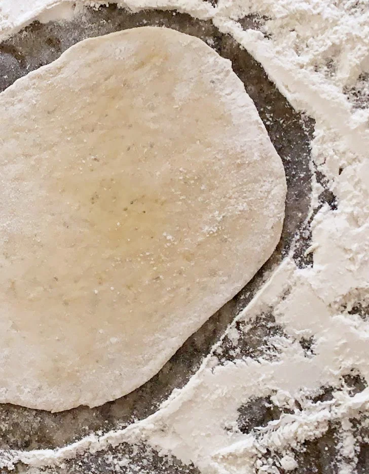 Roll out dough using a rolling pin and flour for a crunchy crust.