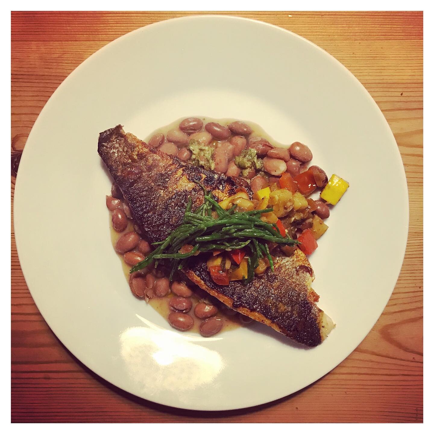 Coming soon to our three course delivery menu: seabass fillet served with braised borlotti beans, vegetable provencal, and an anchovy and herb sauce.