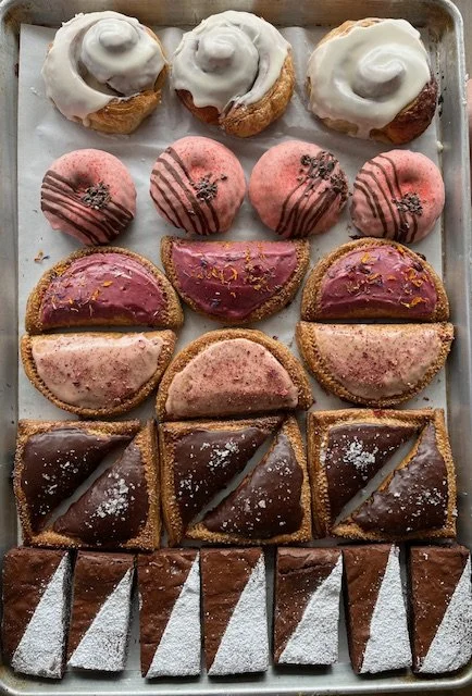 Assorted flaky pastries including croissants and seasonal baked goods displayed on a tray