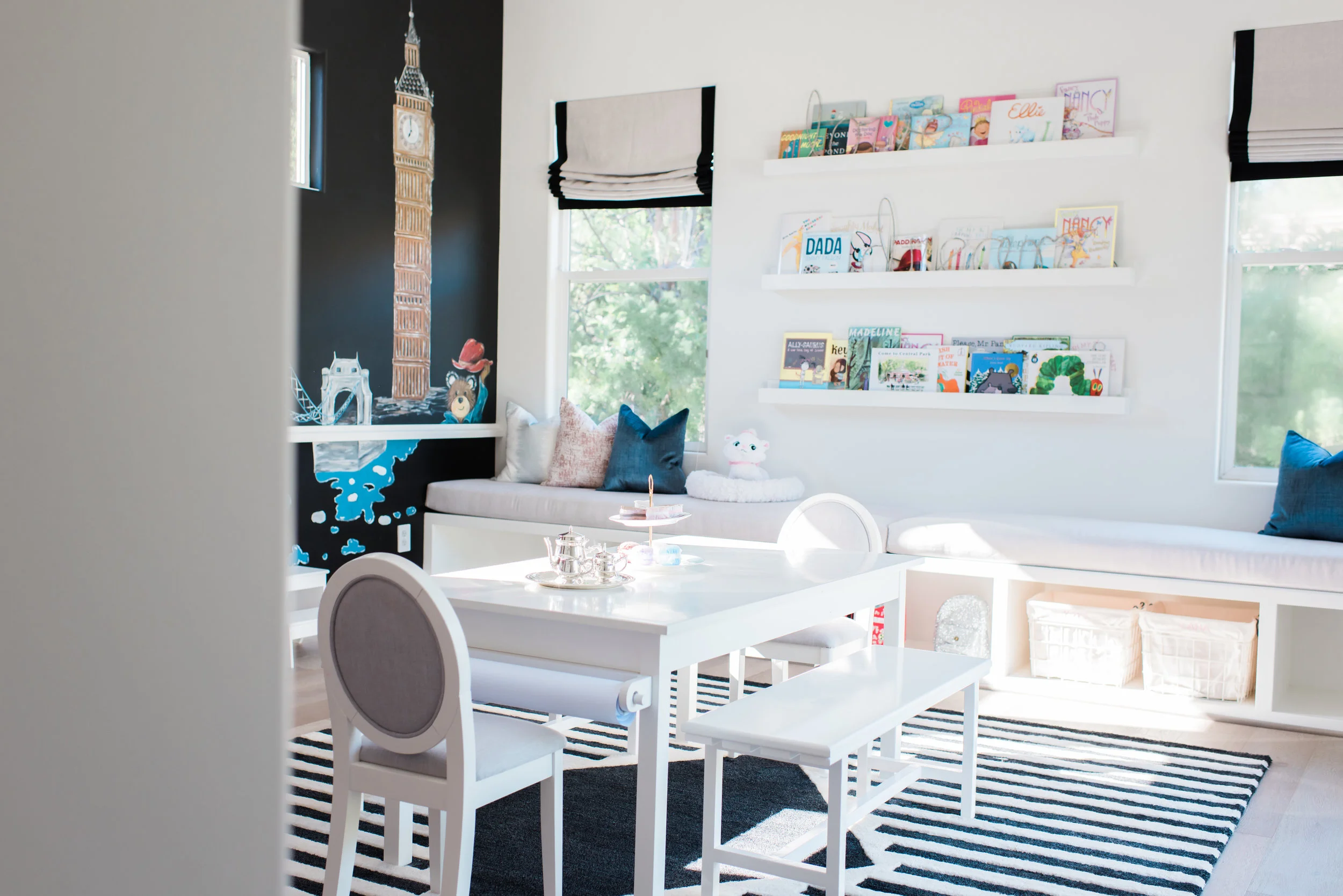 Book shelves and a built-in seating bench in a Play Room designed by Rockabye Mommy