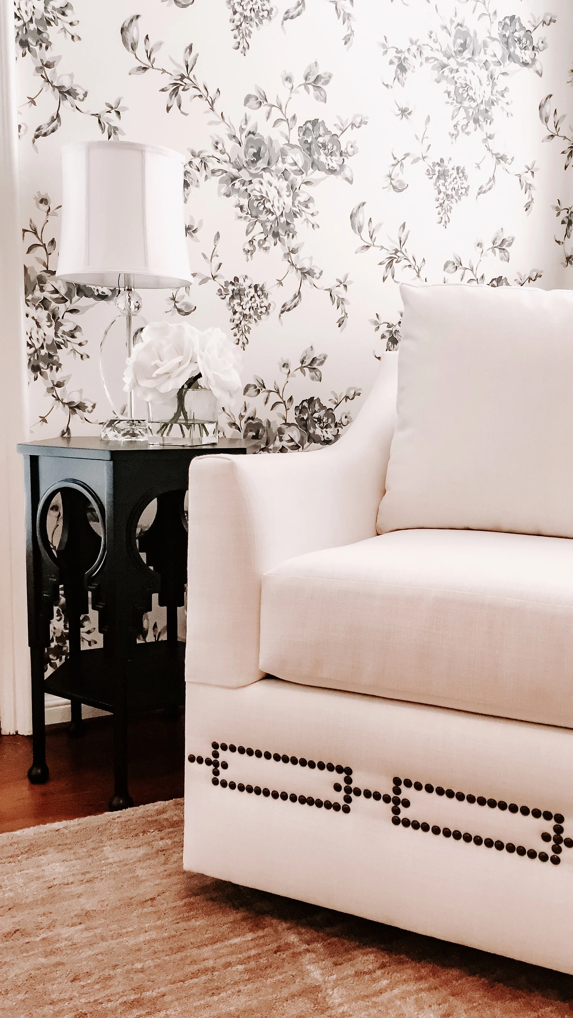 A comfortable glider chair with nailheads in a nursery designed by Rockabye Mommy