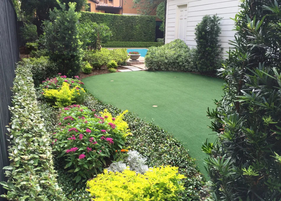 Four cement bowls hold seasonal color and serve as sharp anchor point for the two axes while the undulating lines of the recreational putting green bring an informal element to the garden.