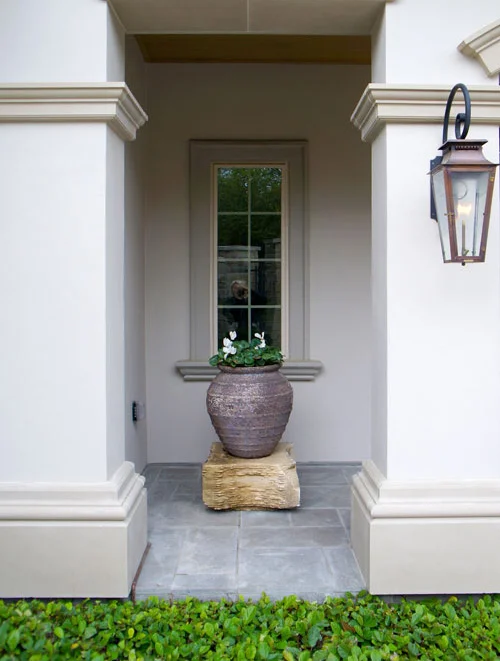 Right: Cyclamen in a centered planter atop a stone pedestal. Sandy Leaf Fig Ivy line the stone patio.