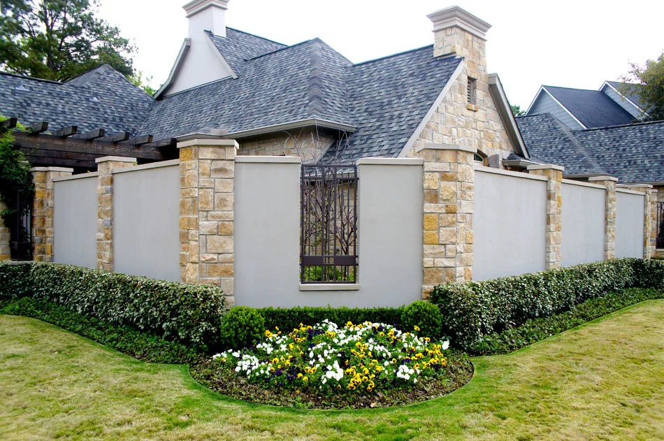 View of home from street corner. Trimmed hedges and Sandy Leaf Fig Ivy, line the wall while boxwoods and seasonal color anchor the corner.