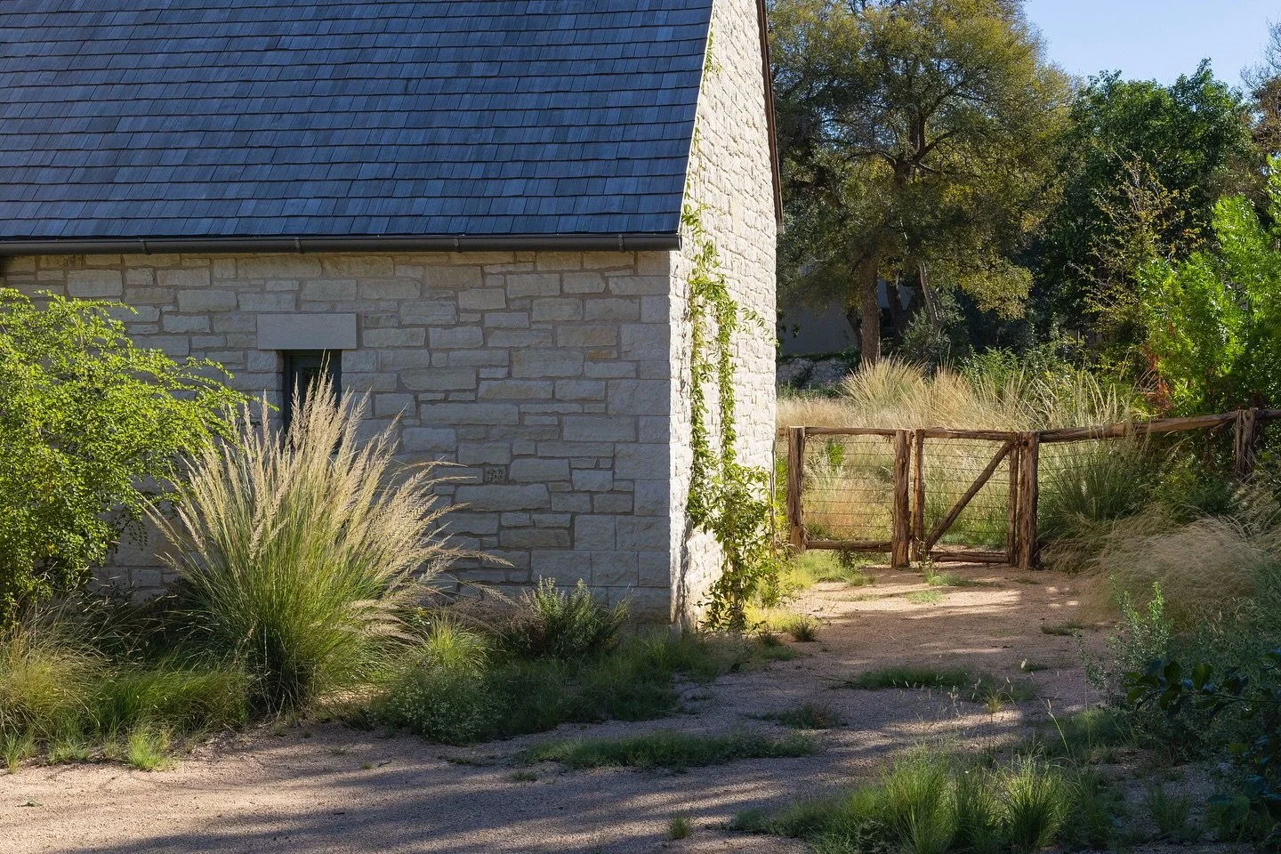 Modern? Farmhouse. 
Every square foot of this property will be covered in native plants once we finish final seeding next spring. Boulder paths are tucked into a sea of native turf sown from seed. Established oaks and cedar elms were under-planted wi