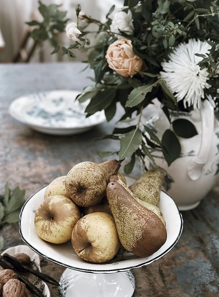 pears on table in pedestal bowl
