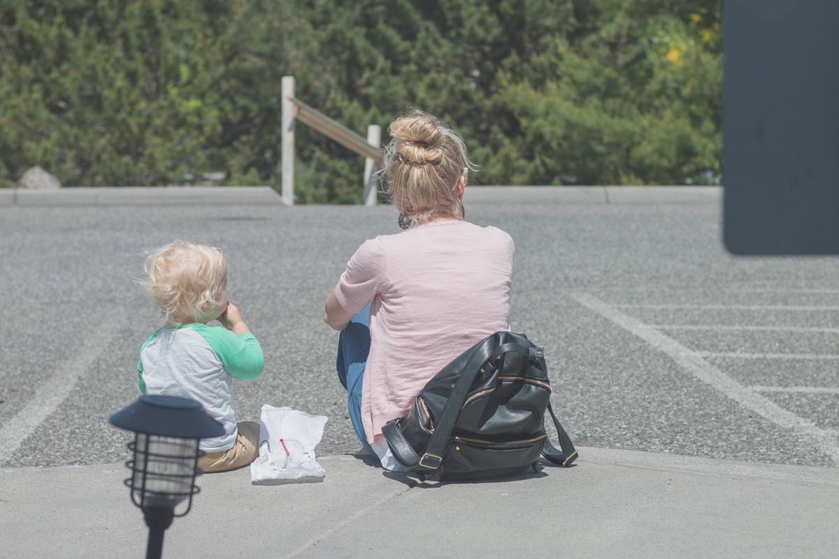 Boy sitting with blonde woman outside coffee shop.