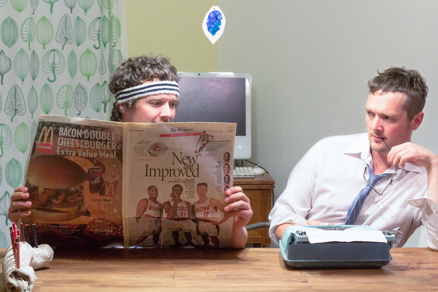 Twins reading newspaper and on typewriter