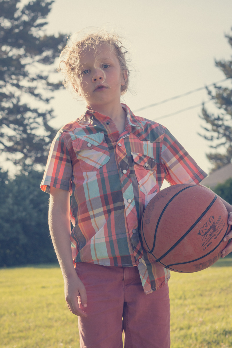 Boy holding basketball on outdoor court