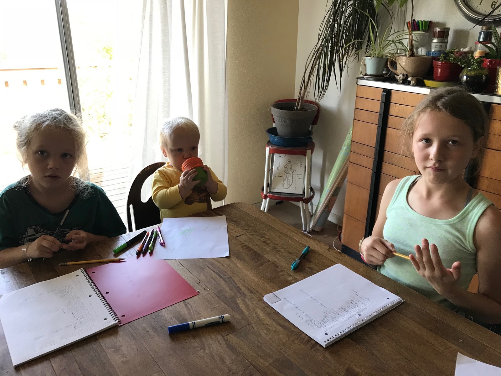 Homeschool children from age 2 to age 11 doing spelling test at table.jpg
