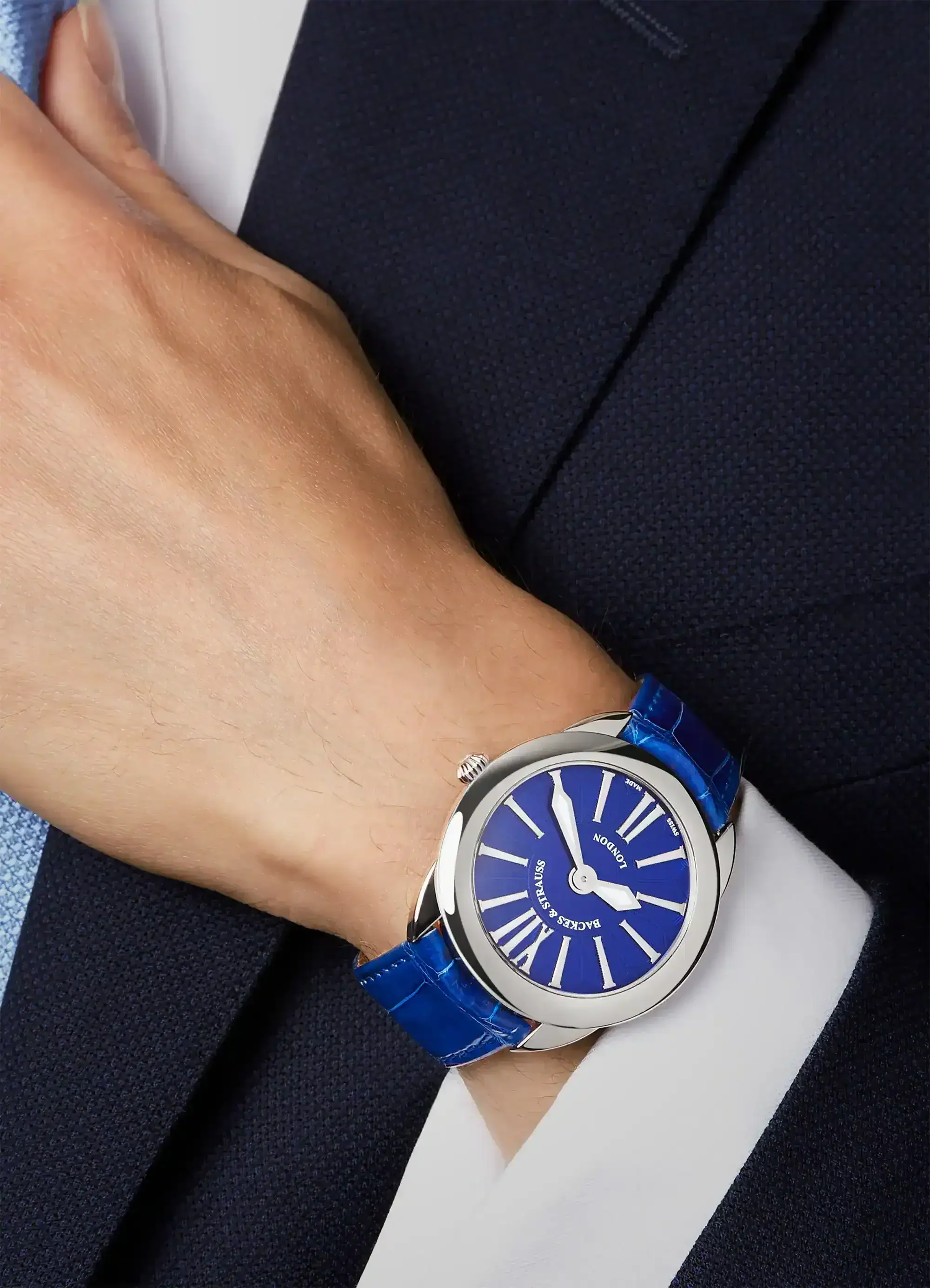 Swiss made men’s watch with steel case, blue dial and leather strap on the wrist.webp