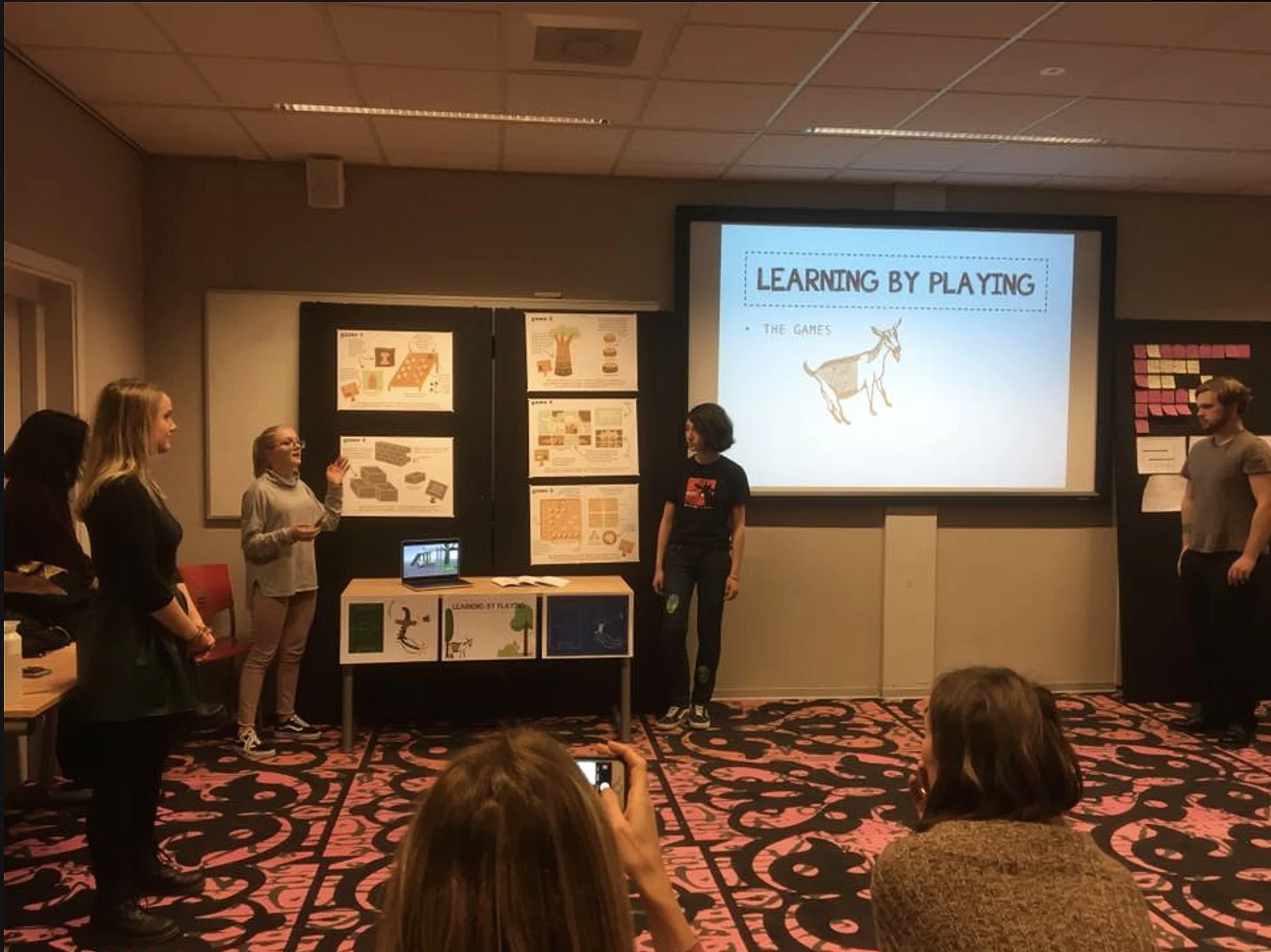 (left to right) Robin, Mariella, Jeanette, Chanina, and Robbert, giving the Learning by Playing final presentation to the President of the Red Cross, the Red Cross representatives, and the other participants of Imagining Tomorrow.