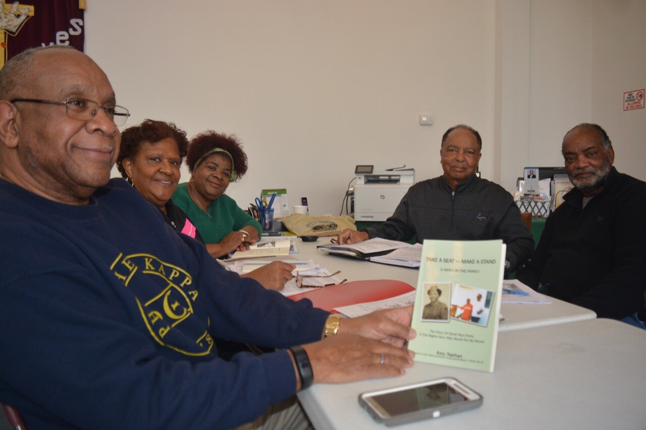  The SKE Project Team, from left to right: Dr. Ervin Griffin, Dr. Georgette Kimball, Mrs. Ophelia Gould-Faison, Dr. Charles McCollum, and artist Napolean Hill. Here Dr. Griffin is holding the book about Mrs. Sarah Keys Evans,  Take a Seat-Make a Stan