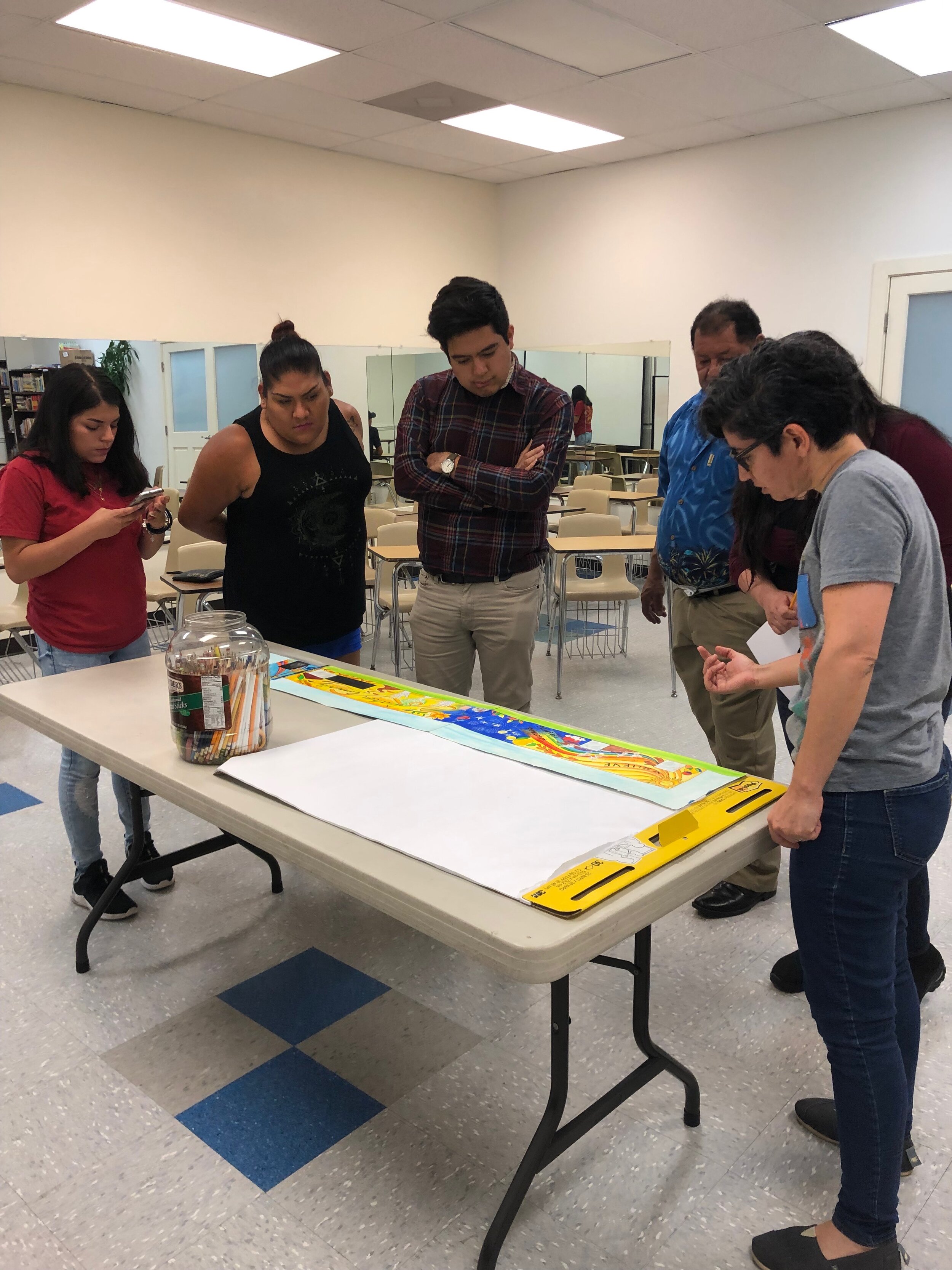  Artist Cornelio Campos synthesizes community ideas to create a first draft of the rendering and here he and artist mentee Estaphanie Sanchez gather feedback from other local Latinx artists.  Photo courtesy of El Futuro  