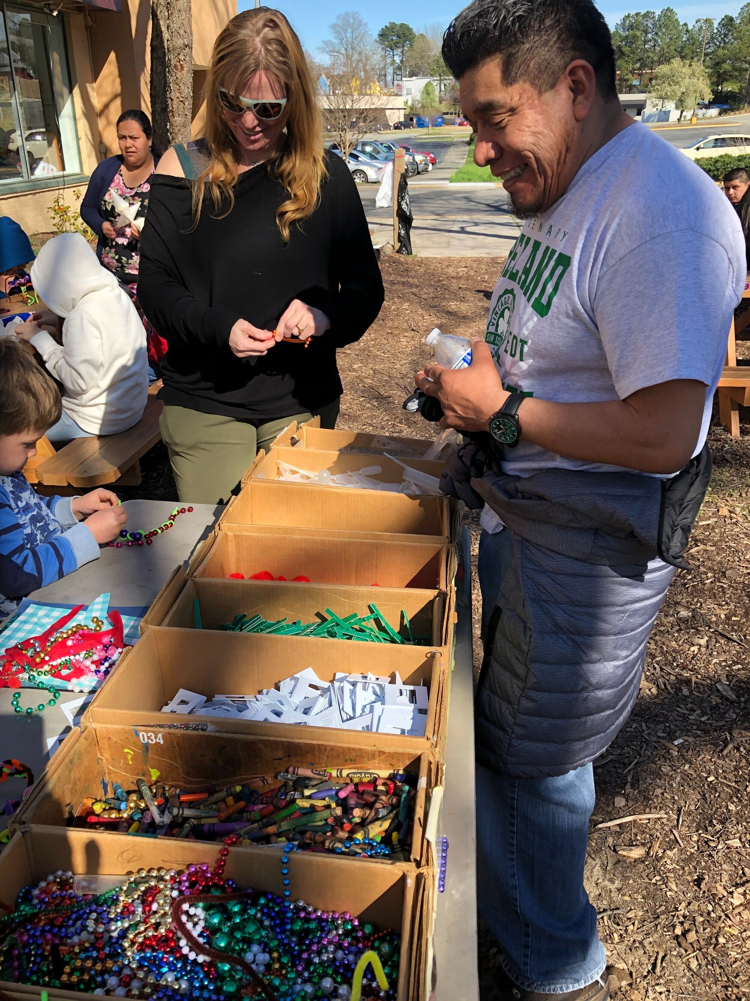  Lead artist Cornelio Campos interacts with community members at the fiesta through a creative activity sponsored by Scrap Exchange, one of El Futuro’s project partners. The gathering of ideas is inspired by hands on art making together.  Photo court