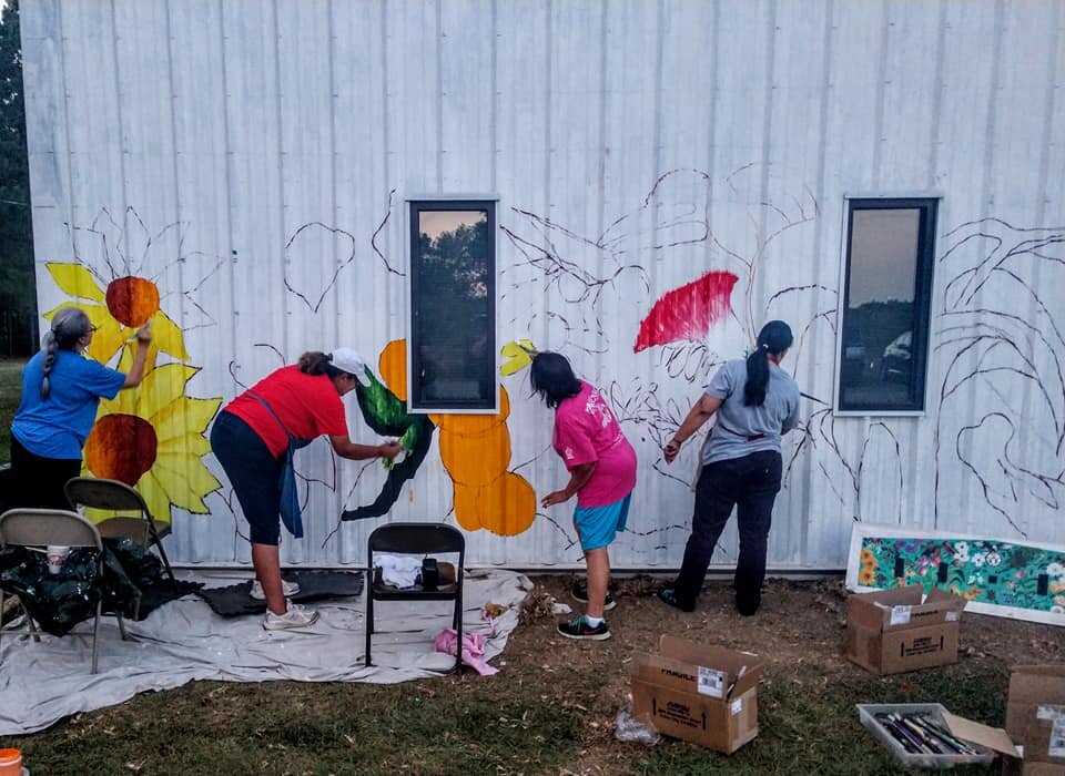  Once the lower portion of the drawing is in place, artist Karen Harley welcomes community volunteers to begin the painting process.  Photo courtesy of Karen Harley  