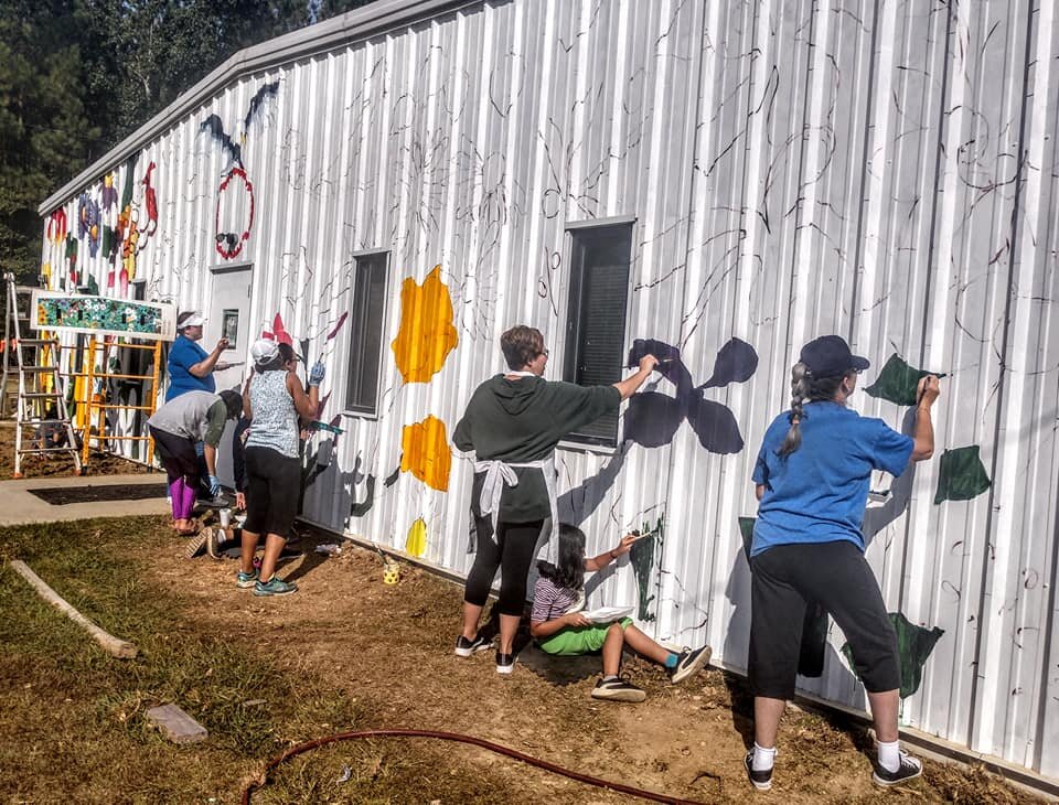  As the mural progresses, the artist team continues to provide opportunities for the whole community to participate.  Photo courtesy of Karen Harley  