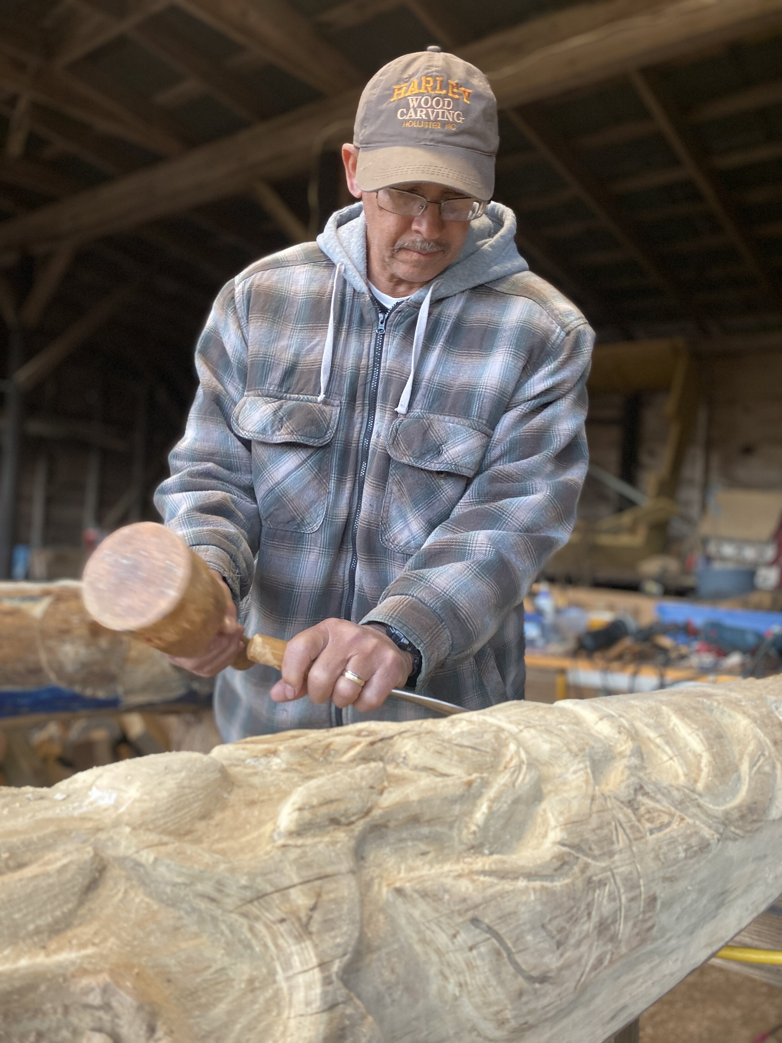  Artist Phillip Harley carves the wood sculptures in his studio that will flank the entrance to the multipurpose building.  Photo courtesy of Brooks Bennett  