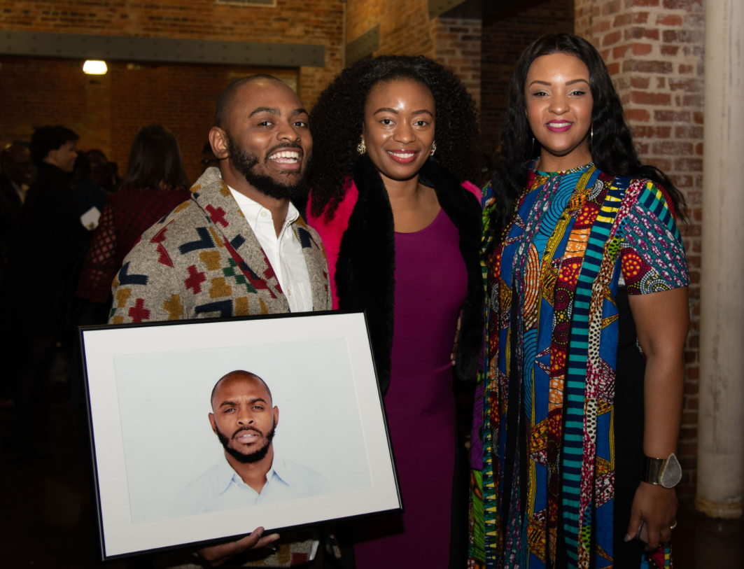  During the reception, project participants were gifted with their framed portrait. Troy Davis (L), along with a friend, pose with BLP Director Tonya Jefferson Lynch (R).  Photo courtesy of Mark Adcox  