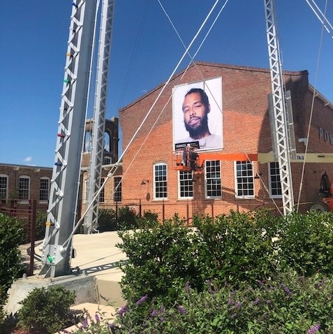  The installation began in June 2020 and this view shows Yannick McLeod’s banner portrait installation almost complete.  Photo courtesy of Alicyn Wiedrich  