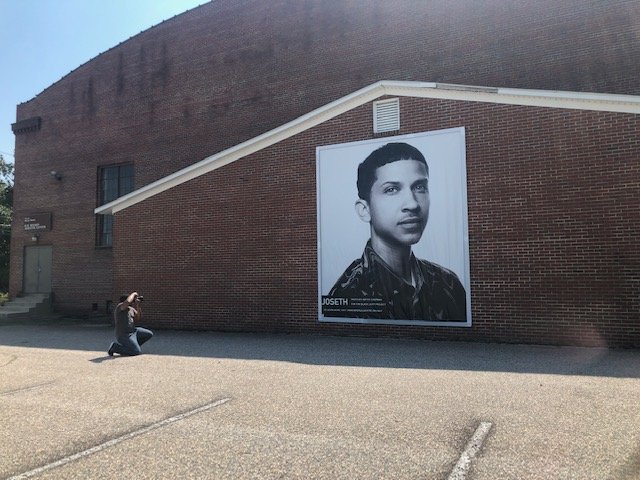  Photographer Bryce Chapman returns to the R.M. Wilson Gymnasium to capture photographs of the final installation of JoSeth Bocook’s banner portrait.  Photo courtesy of Alicyn Wiedrich  