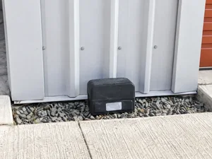 Pest-control bait station beside a storage unit
