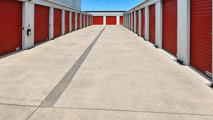 Drainage channel running along the concrete driveway between Storage4Less units