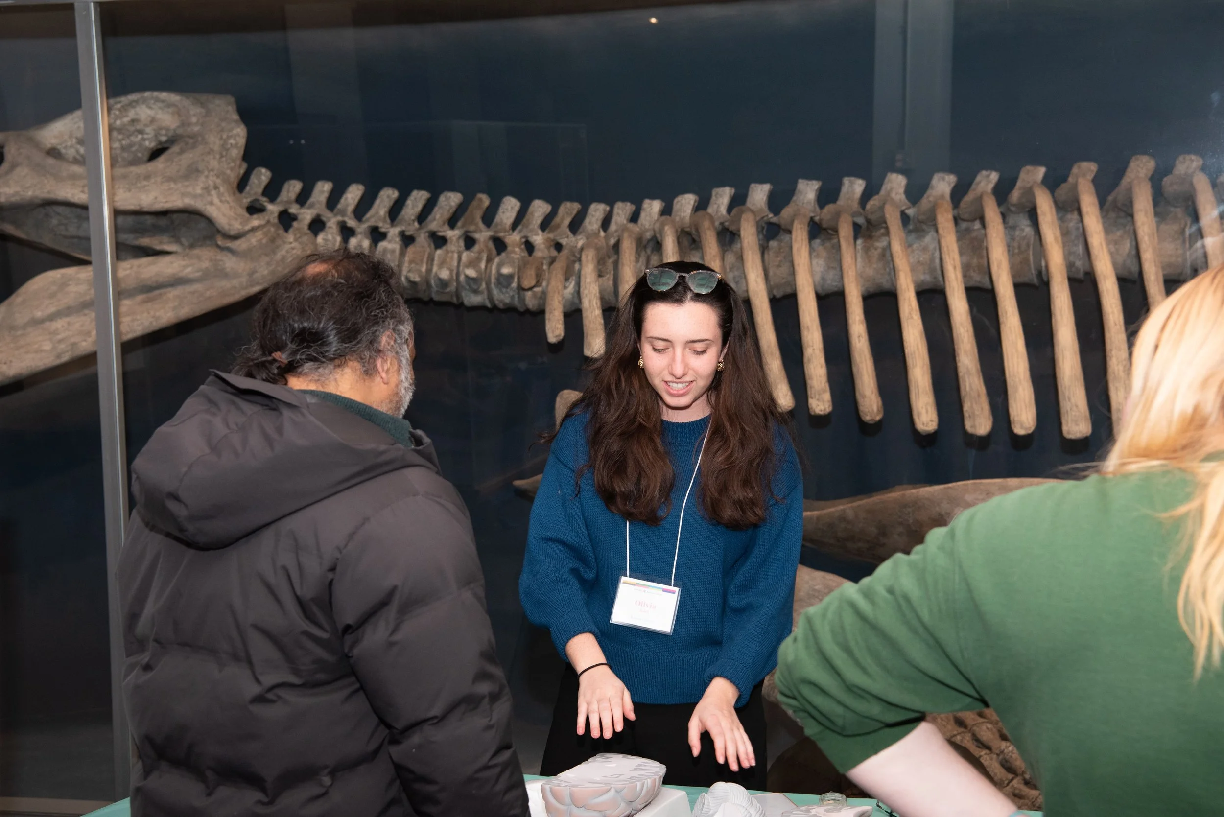 Research assistant explaining a large brain model to a guest at a recruitment event