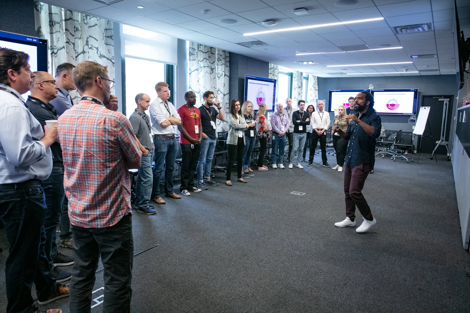 Didier Sylvain facilitating a leadership cohort standing in a circle in a corporate training room